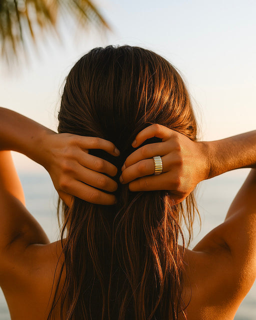 Bold gold statement ring photographed on sun-kissed skin