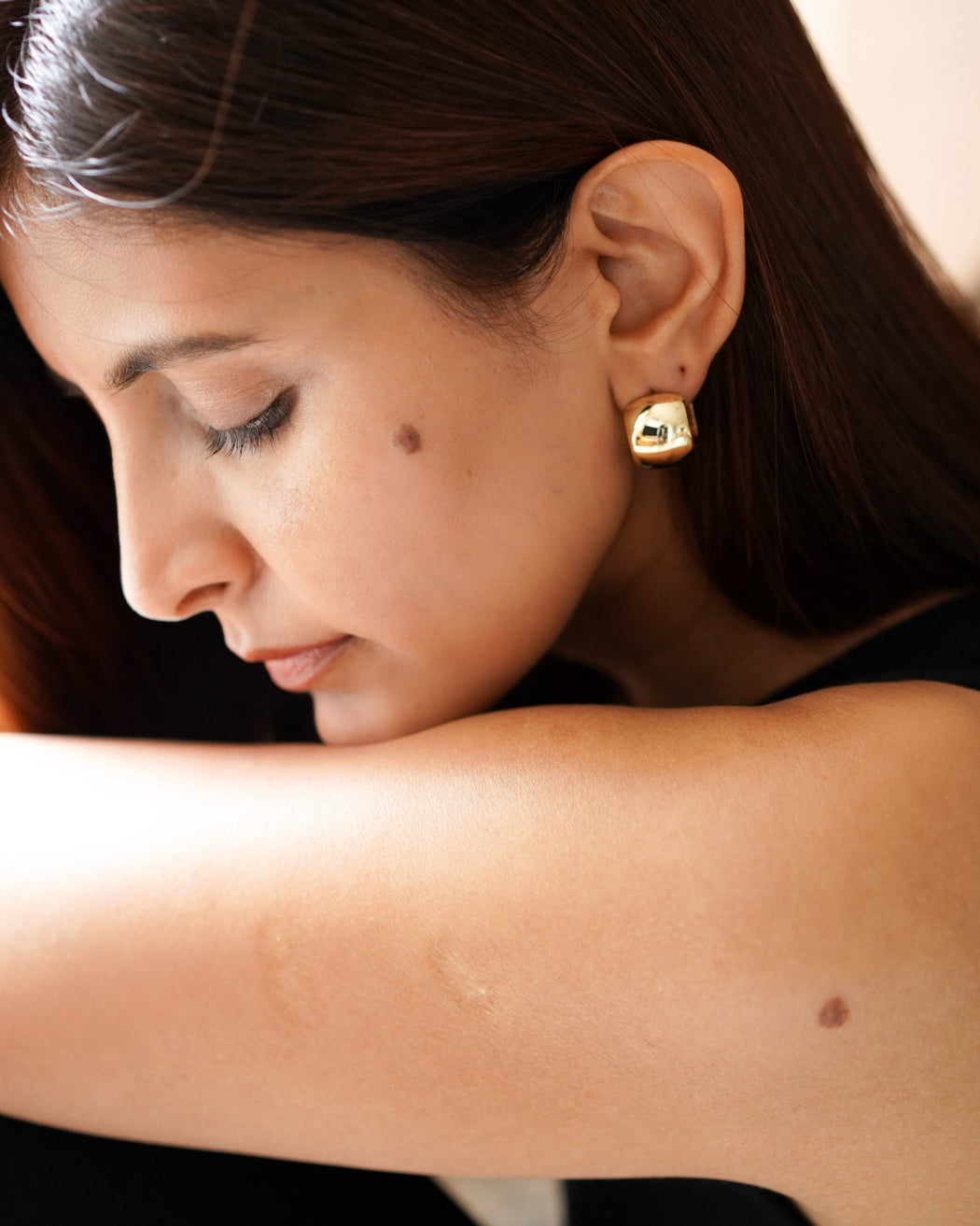 Woman wearing chunky 18K gold-filled hoop earrings

