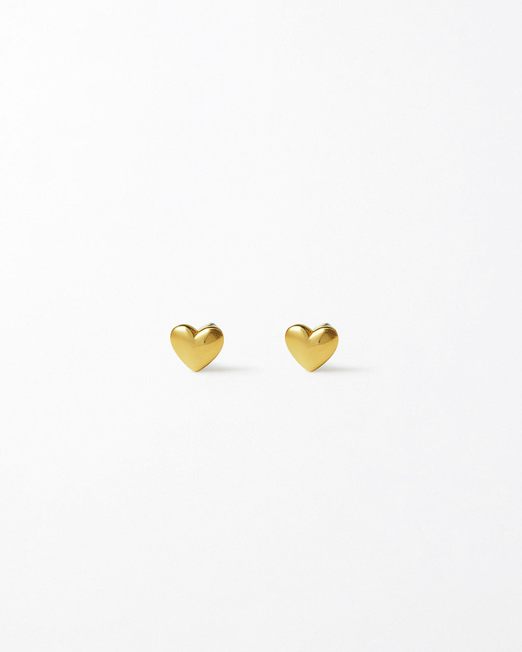 Two gold heart-shaped earrings on a white background
