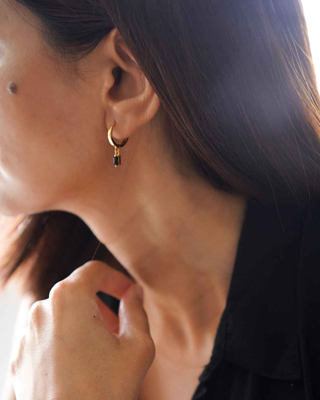Model wearing Scarlett minimalist gold dangle earrings with sleek pulled-back hairstyle