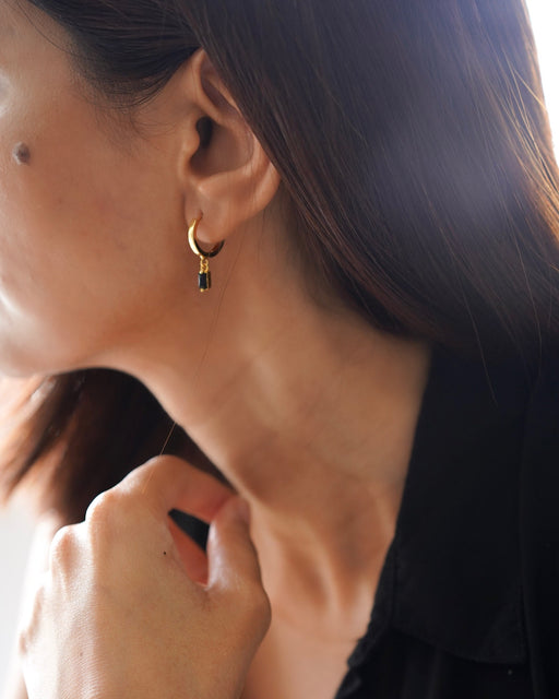 Model wearing Scarlett minimalist gold dangle earrings with sleek pulled-back hairstyle