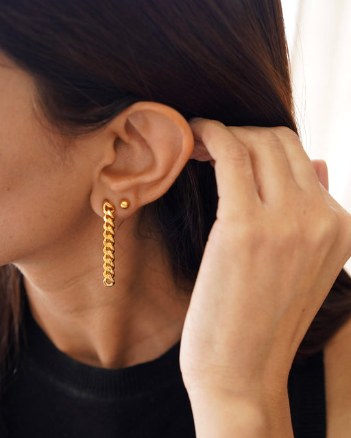 Model wearing Ariana gold chain earrings with hair pulled back