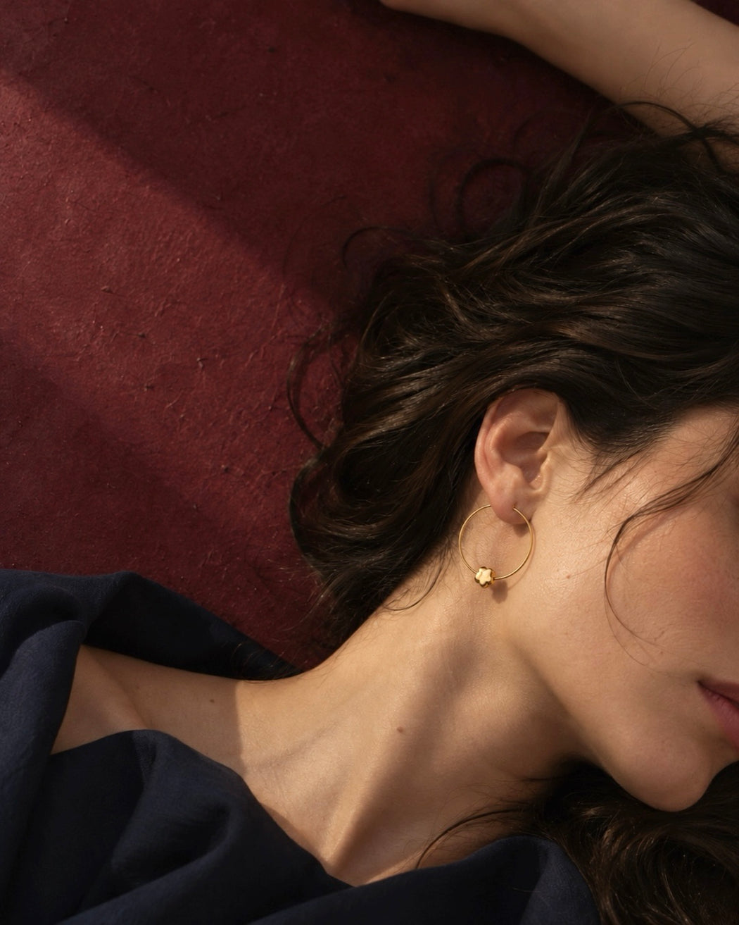 Model wearing CHLOE minimalist gold floral hoop earrings with delicate flower charms