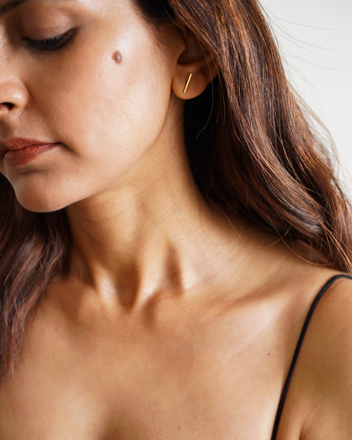 Gold-plated bar studs styled on model for a minimalist everyday look 