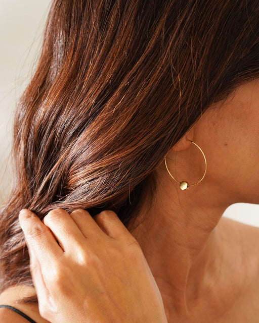 Model wearing Jamie gold hoops with hair pulled back